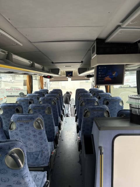 Scaunele tapițate în albastru și portbagajele din autocarul de 50 de locuri