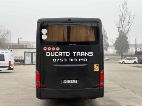 Spatele autocarului de 50 de locuri, cu inscripția Ducato Trans și perdele la lunetă