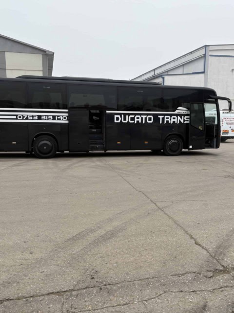 Autocarul de 50 de locuri Ducato Trans, din lateral, cu ușa din mijloc deschisă