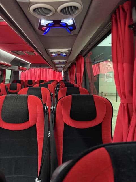 Interiorul microbuzului de 30 de locuri, cu guri de aer și lămpi de citit deasupra fiecărui rând