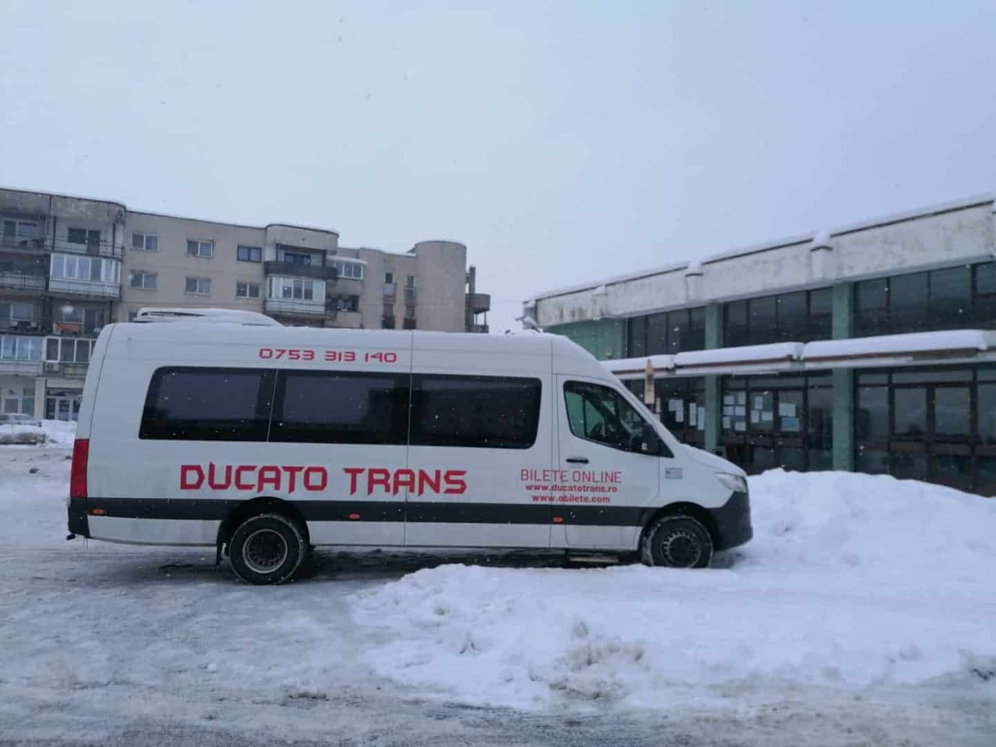 Microbuz Ducato Trans în fața autogării, pe zăpadă